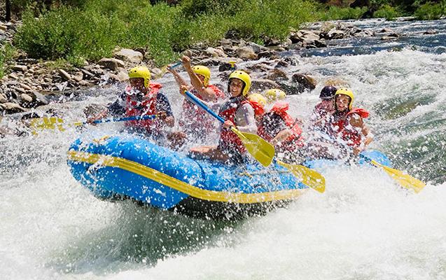 Group of young adults whitewater rafting